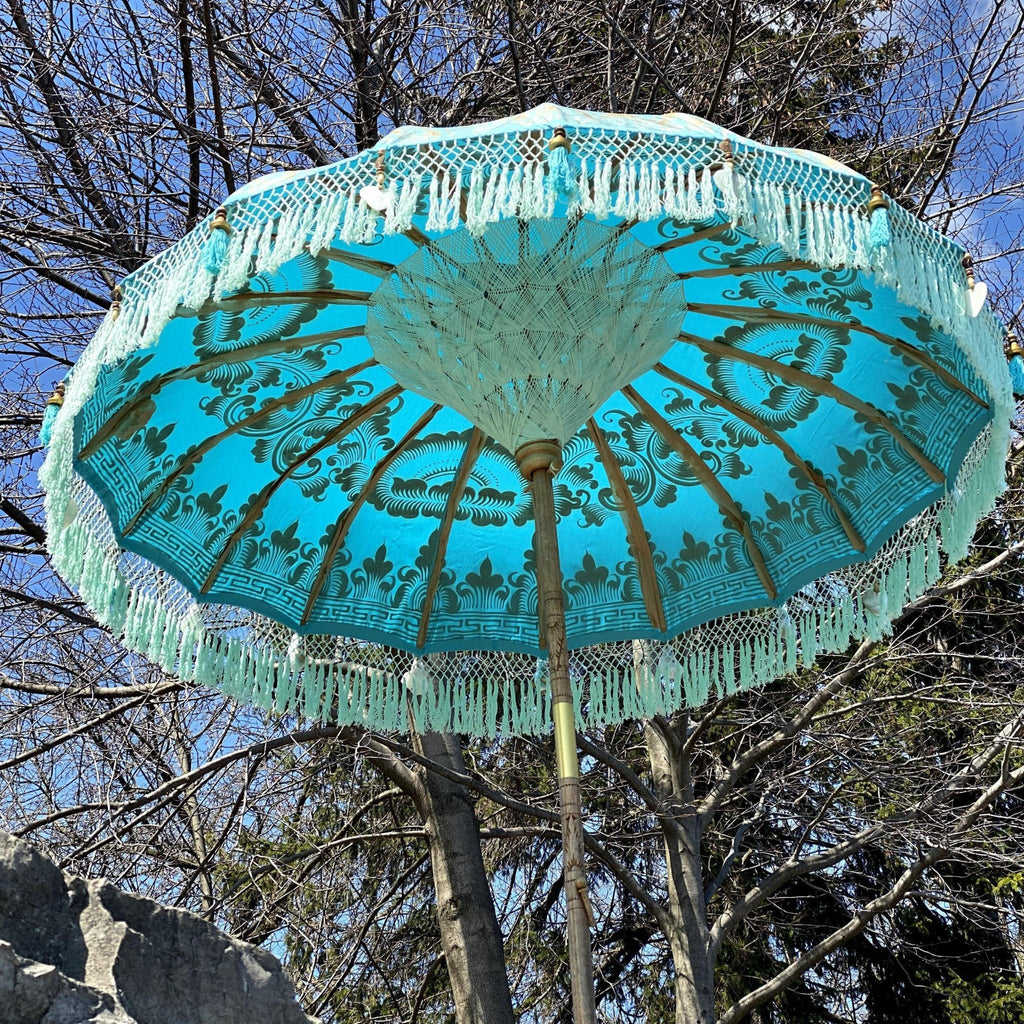 legant Big Jack Parasol in turquoise with gold accents, featuring handcrafted wooden pole and bamboo spokes.
