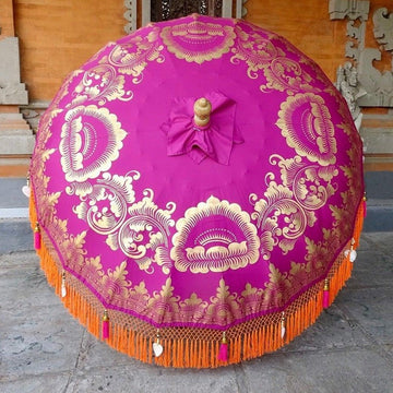 Cecilia Parasol with pink and purple canvas adorned with gold hand-painted designs and bright orange fringe.