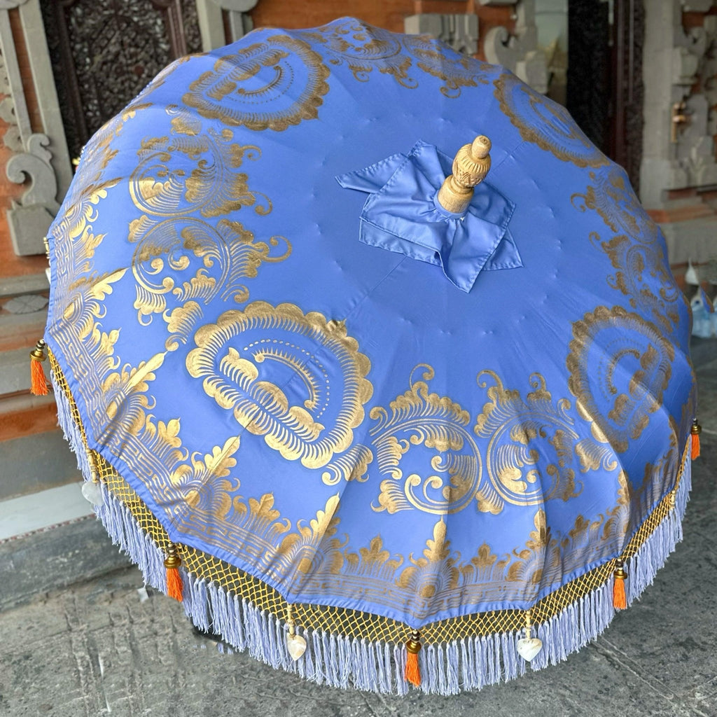 Charlotte Parasol adding a luxurious and tropical touch to a garden or patio setting with its elegant design and vibrant colors.